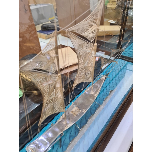 52 - A filigree large boat in a case, having very intricate details, and ornate figures on the Sails. Att... 