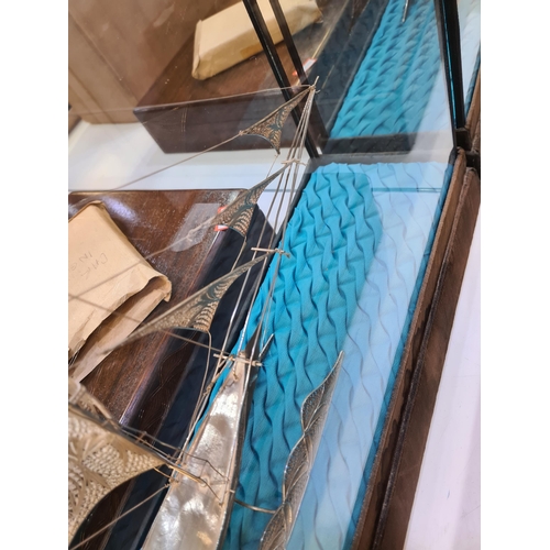 52 - A filigree large boat in a case, having very intricate details, and ornate figures on the Sails. Att... 