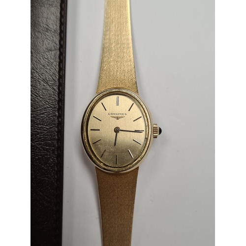 1102 - Longines; A 14K yellow gold ladies cocktail watch with oval golden dial, and baton markers, marked 5... 