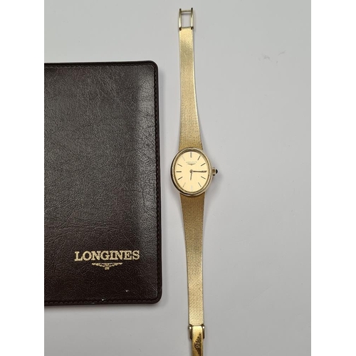 1102 - Longines; A 14K yellow gold ladies cocktail watch with oval golden dial, and baton markers, marked 5... 