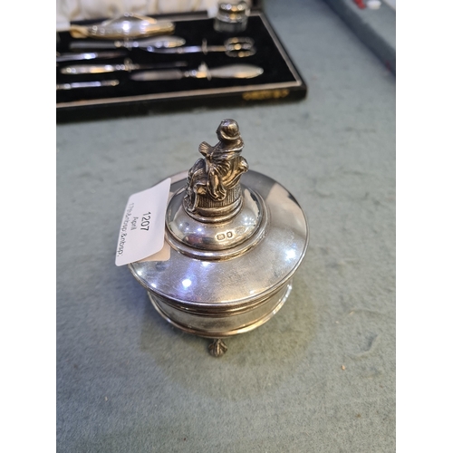 A silver trinket box having hallmarks by Levi and Salaman, and Goldsmiths and Silversmith Co Ltd.  On three claw and ball feet with a figure finial.  Total gross weight approx 3.97 ozt.  Condition report: some denting