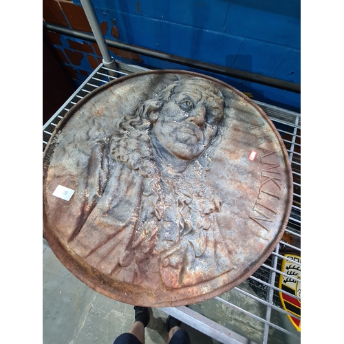 A cast iron circular wall plaque of Benjamin Franklin, 55cm.