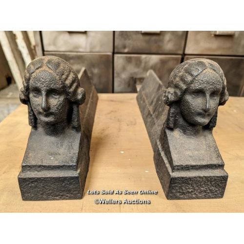 103 - Pair of cast iron fire dogs or door stops with ladies' faces. 36cm L x 16cm H x 6.5cm W