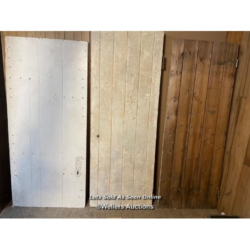 152 - 3 planked pine doors. All painted pine. Sizes 67cm by 180cm. 75 by 169 cm and 66cm by 176cm