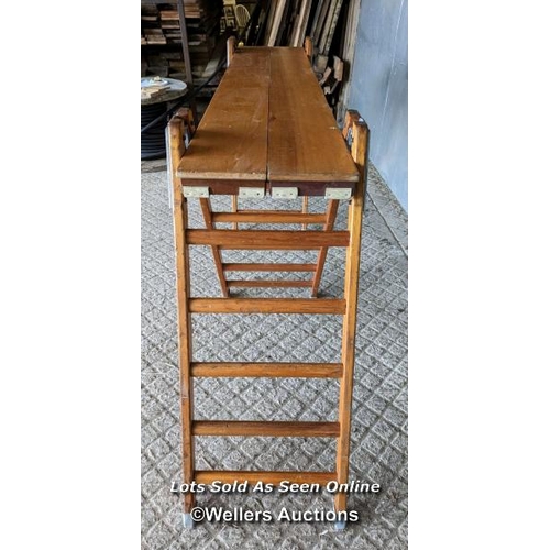 51 - The London Gymnasium company bench. Beech or hardwood with metal brackets. 289cm W x 52cm D x 106cm ... 