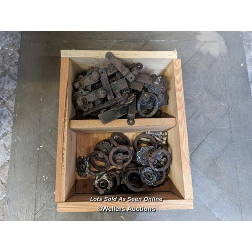 324 - A box of 14 sets of rustic door latches. Cast iron.Each set includes a circular drop handle with 'fl... 