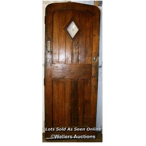 327 - An oak Arts and Crafts front door with diamond glass bullseye. The door is morticed and tenoned and ... 