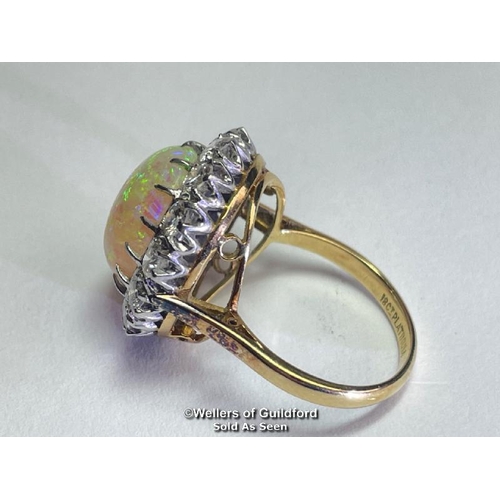 352 - Opal and diamond cluster ring with an oval opal measuring 14.6mm x 12.2mm surrounded by 14 round bri... 