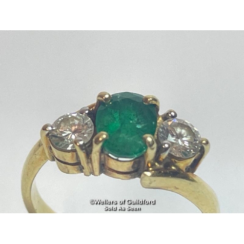 340 - An emerald and diamond three stone ring in crossover style. Emerald measures approx 6.9 x 5.1 x 3.5m... 