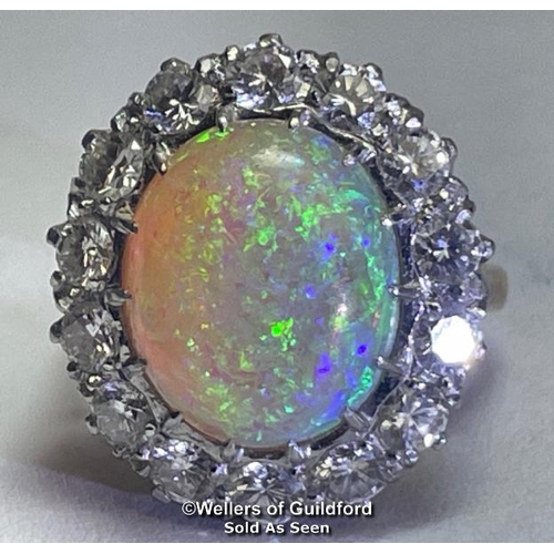 352 - Opal and diamond cluster ring with an oval opal measuring 14.6mm x 12.2mm surrounded by 14 round bri... 