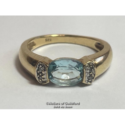 381 - Oval blue topaz (untested) ring in yellow metal stamped 585, with diamond accents. Ring size K1/2, w... 