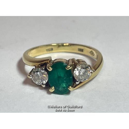 340 - An emerald and diamond three stone ring in crossover style. Emerald measures approx 6.9 x 5.1 x 3.5m... 