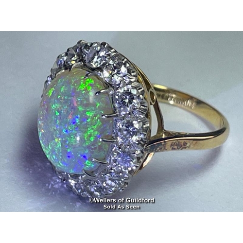 352 - Opal and diamond cluster ring with an oval opal measuring 14.6mm x 12.2mm surrounded by 14 round bri... 