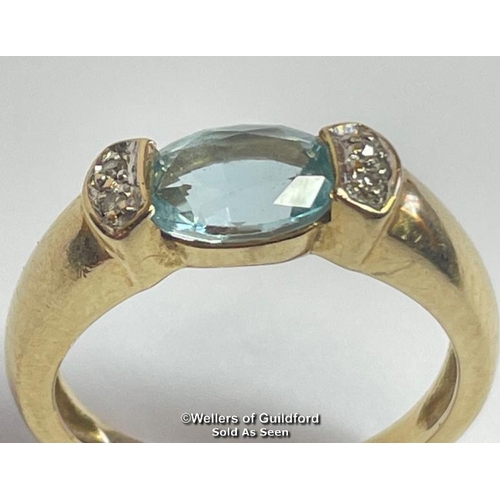 381 - Oval blue topaz (untested) ring in yellow metal stamped 585, with diamond accents. Ring size K1/2, w... 