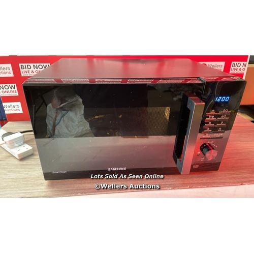 7052 - SAMSUNG MICROWAVE ( S/N 0C9Q7WFR500352R) / POWERS UP / SIGNS OF USE / DENTED / G12