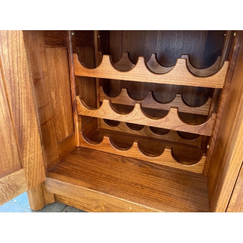 17 - LARGE OAK DISPLAY CABINET, TWO DRAWERS WITH TWO CUPBOARD DOORS BELOW, INCL. TWELVE BOTTLE WINE RACK,... 