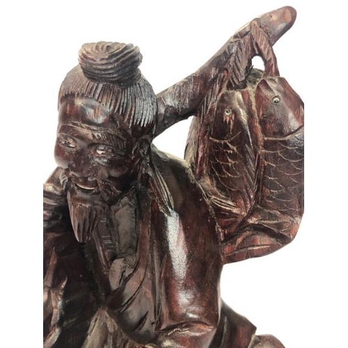 16 - A carved hardwood figure of a fisherman and child, 30cm high / AN3