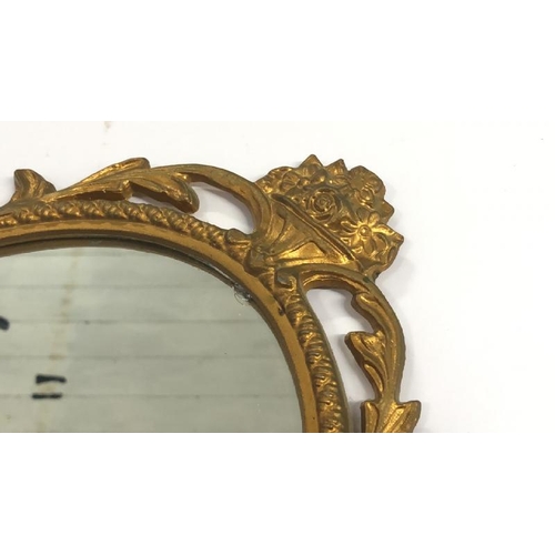 36 - A small oval wall mirror with decorative metal frame, 48cm high