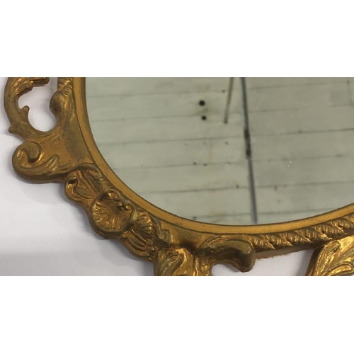 36 - A small oval wall mirror with decorative metal frame, 48cm high