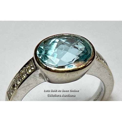 158 - An aquamarine and diamond ring in hallmarked 18ct gold. The checquer board cut oval aquamarine measu... 