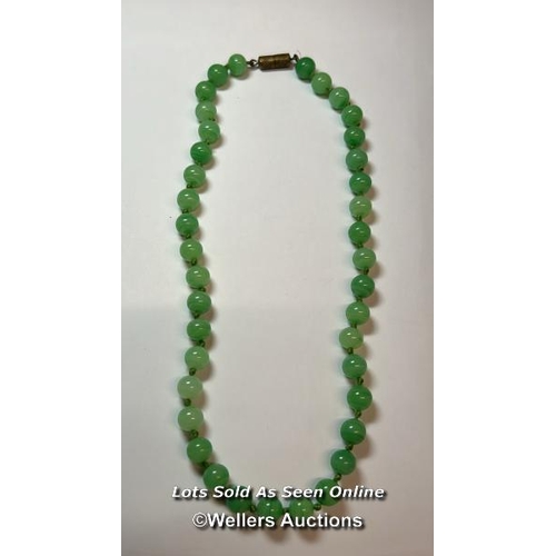 185 - Green glass bead necklace, string knotted to base metal barrel clasp. Length 40cm, with a plastic an... 