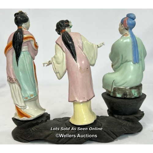 52 - a group of three Japanese famille rose porcelain figures on a carved wooden base, 16cm high / AN9