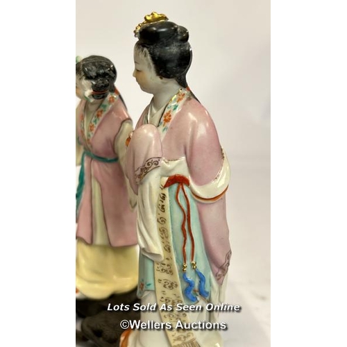 52 - a group of three Japanese famille rose porcelain figures on a carved wooden base, 16cm high / AN9