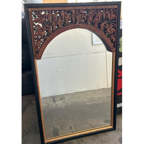 124 - A carved and painted gilt Chinese mirror, with oriental figures in a relief arch at top, 65 x 104cm ... 