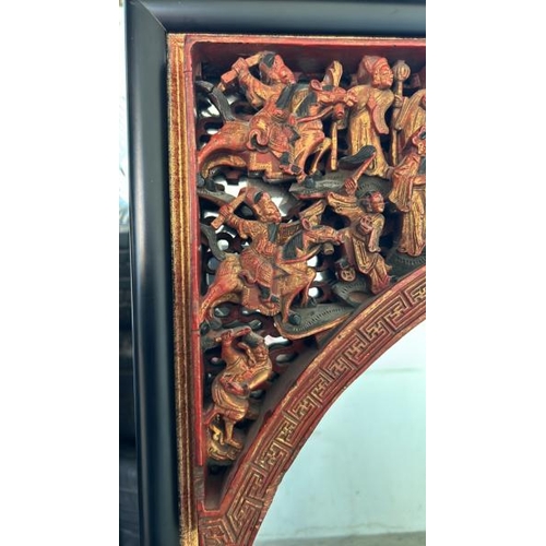 124 - A carved and painted gilt Chinese mirror, with oriental figures in a relief arch at top, 65 x 104cm ... 