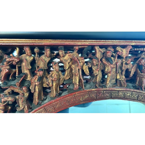 124 - A carved and painted gilt Chinese mirror, with oriental figures in a relief arch at top, 65 x 104cm ... 