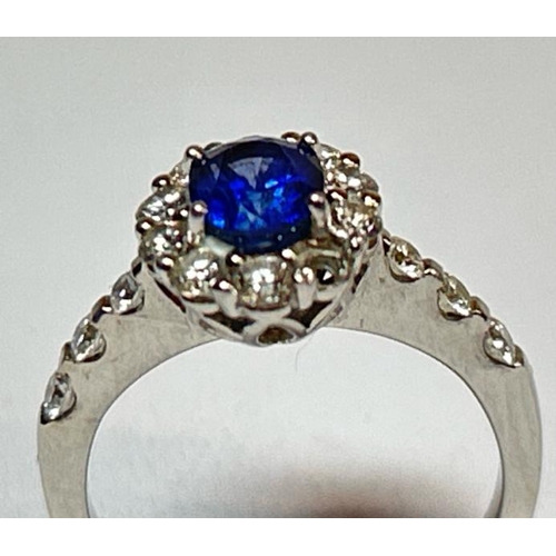 222 - A saphire and diamond cluster ring with diamond set shoulders, one diamond missing, in hallmarked 18... 