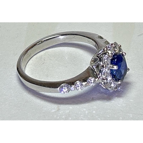 222 - A saphire and diamond cluster ring with diamond set shoulders, one diamond missing, in hallmarked 18... 