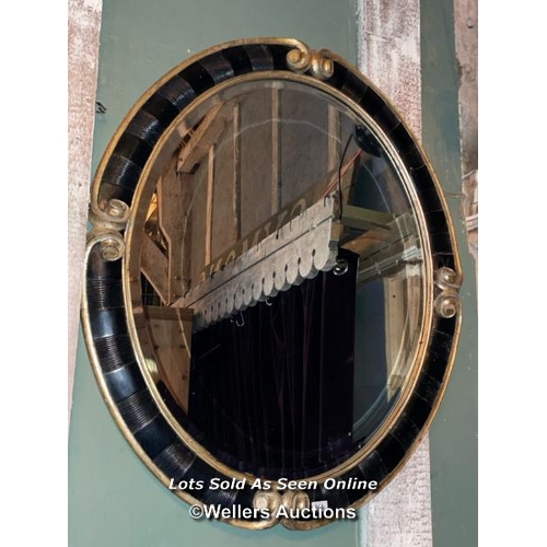 503 - PAIR OF 20TH CENTURY BLACK AND GILDED OVAL MIRRORS, 94 X 110CM (ONE MIRROR PLATE BROKEN)