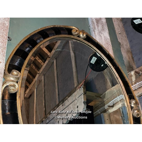 503 - PAIR OF 20TH CENTURY BLACK AND GILDED OVAL MIRRORS, 94 X 110CM (ONE MIRROR PLATE BROKEN)