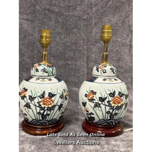 92 - Pair of ceramic table laps, decorated with flowers on wooden base with lamp shades, both need plugs,... 