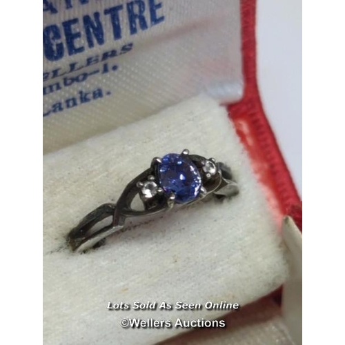 329 - Oval sapphire and white sapphire ring in unmarked white metal testing as silver, ring size M, with a... 