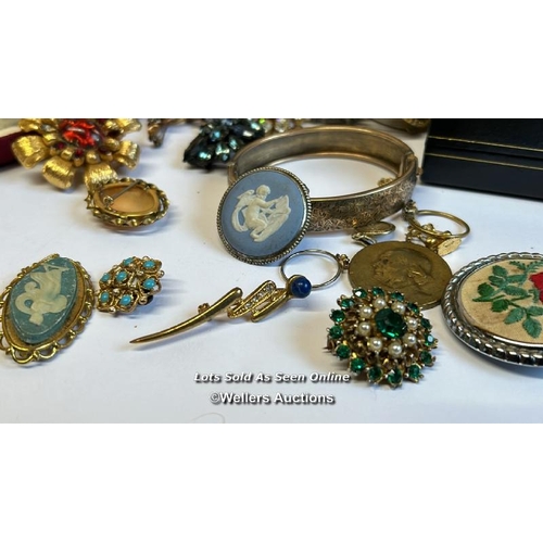 334 - Bag of assorted costume jewellery, mostly brooches, a hinged bangle stamped gold on silver, a gold p... 