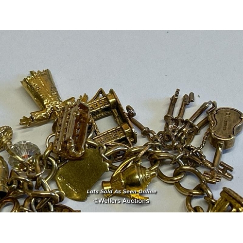 332 - A hallmarked 9ct gold bracelet supporting twenty 9ct gold charms, gross weight 47.07g / SF