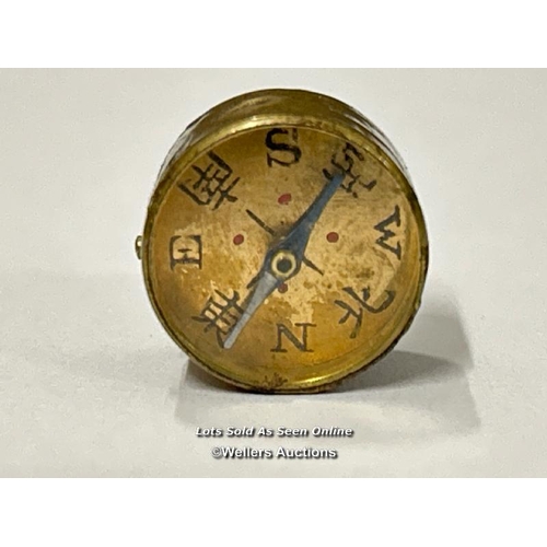 76 - Two very small brass compasses, both 1.5cm diameter. One has Chinese numerals with a printed clock o... 