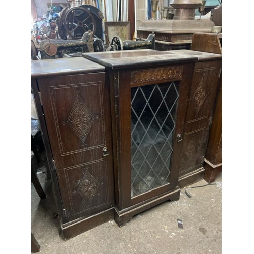 15 - An oak cupboard with carved side panels and glass display centrepiece, not including internal conten... 