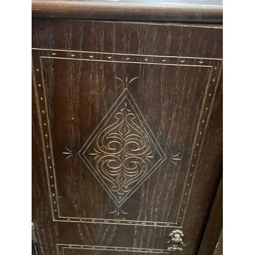 15 - An oak cupboard with carved side panels and glass display centrepiece, not including internal conten... 