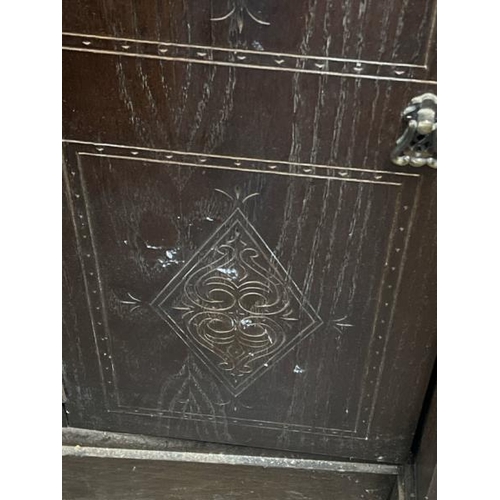 15 - An oak cupboard with carved side panels and glass display centrepiece, not including internal conten... 