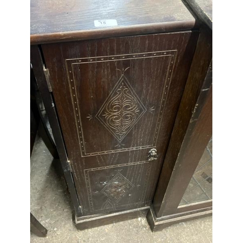 15 - An oak cupboard with carved side panels and glass display centrepiece, not including internal conten... 