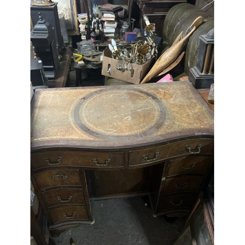 31 - A bow fronted oak desk with leather top inlay, 77cm high x 91cm wide x 52cm deep