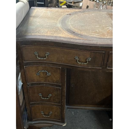 31 - A bow fronted oak desk with leather top inlay, 77cm high x 91cm wide x 52cm deep