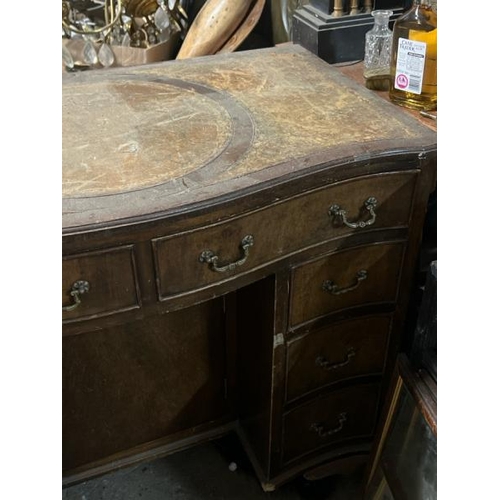 31 - A bow fronted oak desk with leather top inlay, 77cm high x 91cm wide x 52cm deep