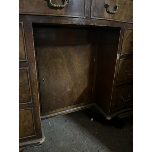 31 - A bow fronted oak desk with leather top inlay, 77cm high x 91cm wide x 52cm deep