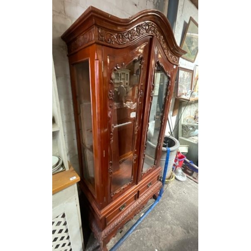 48 - An ornately carved display cabinet with two internal shelves and two drawers underneath, 197cm high ... 