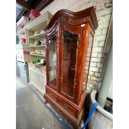 48 - An ornately carved display cabinet with two internal shelves and two drawers underneath, 197cm high ... 