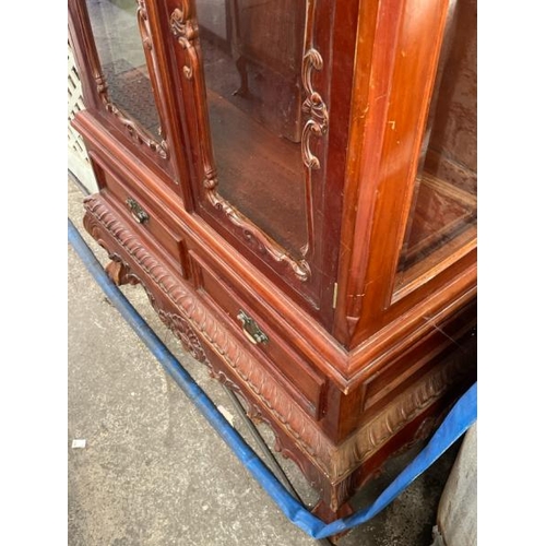 48 - An ornately carved display cabinet with two internal shelves and two drawers underneath, 197cm high ... 